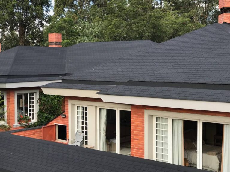 vista frontal de una casa cuyo techo está cubierto de tejas color negro